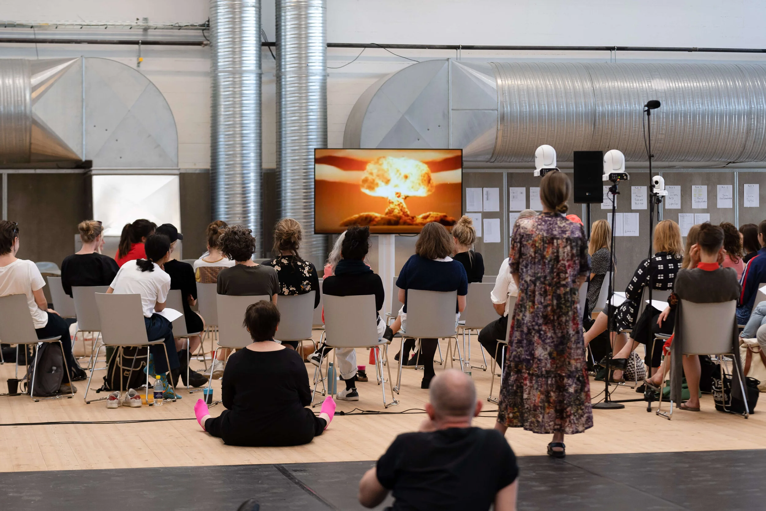 People watching a film on a large tv screen.