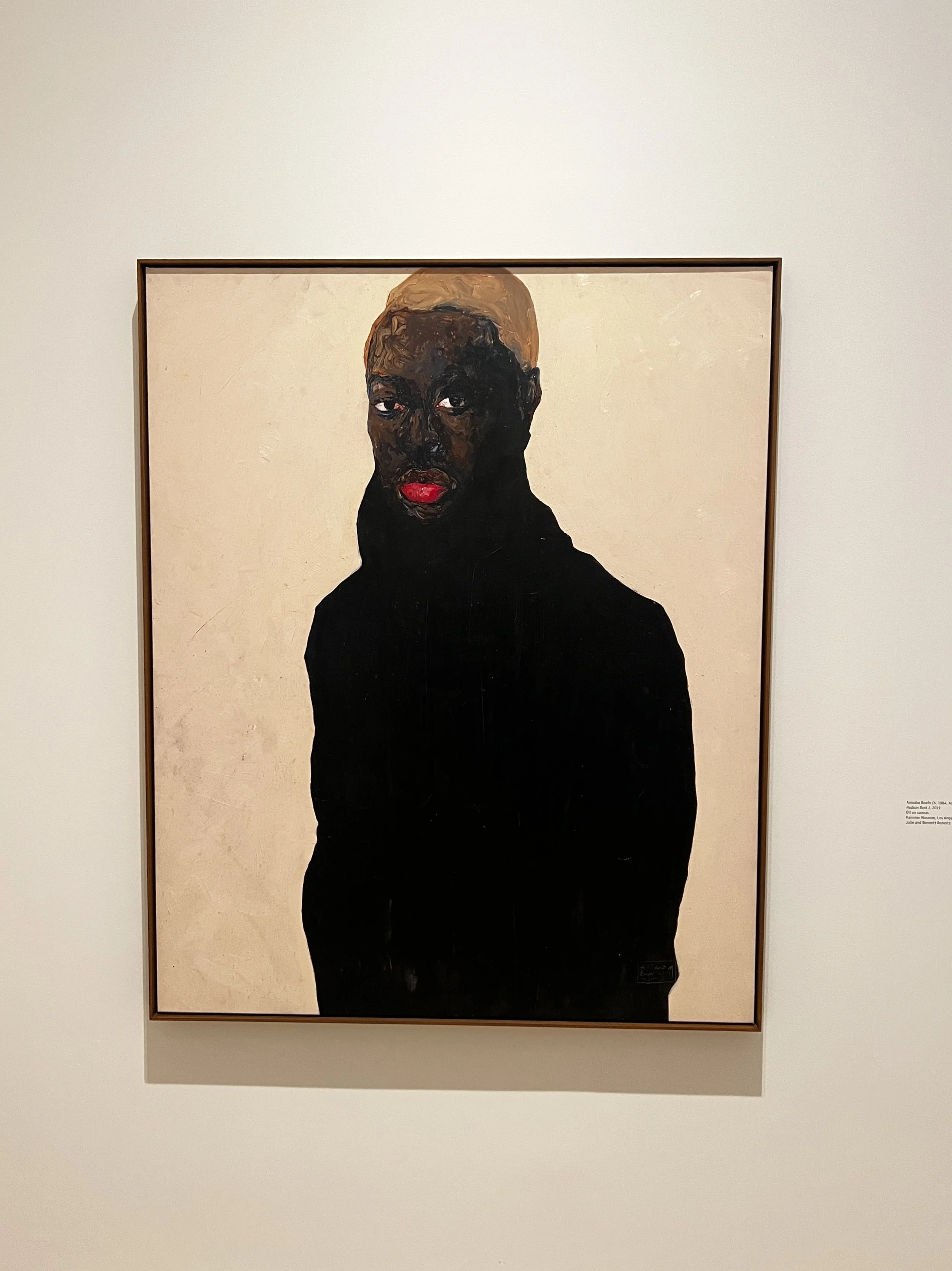 Painting of a person with dark skin, short blond hair, wearing a black turtleneck, and bright red lipstick, against a light background.