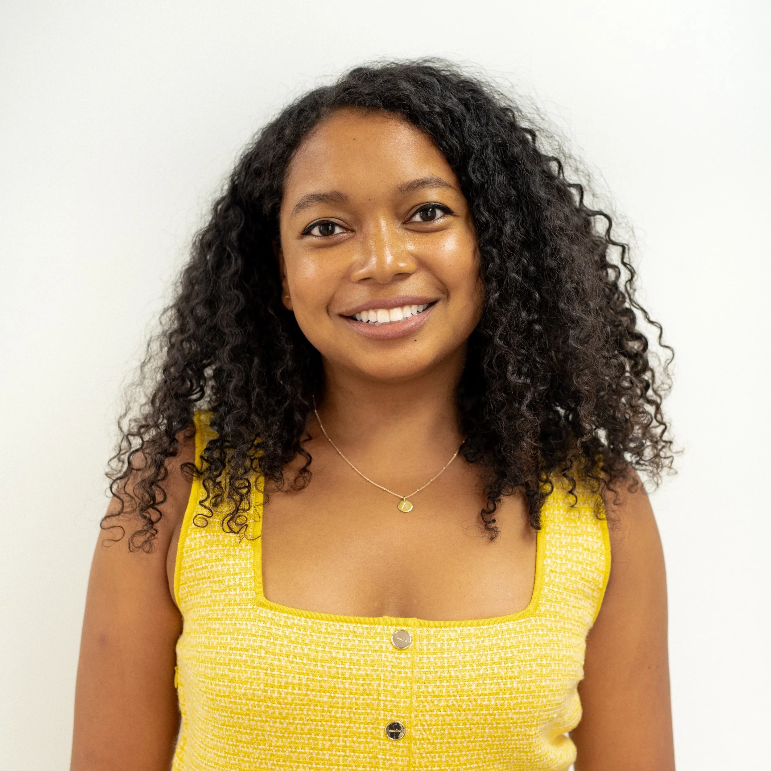 Abadesi Osunsade stands for a profile press shot to promote her new course on negotiating a better salary, in a yellow dress