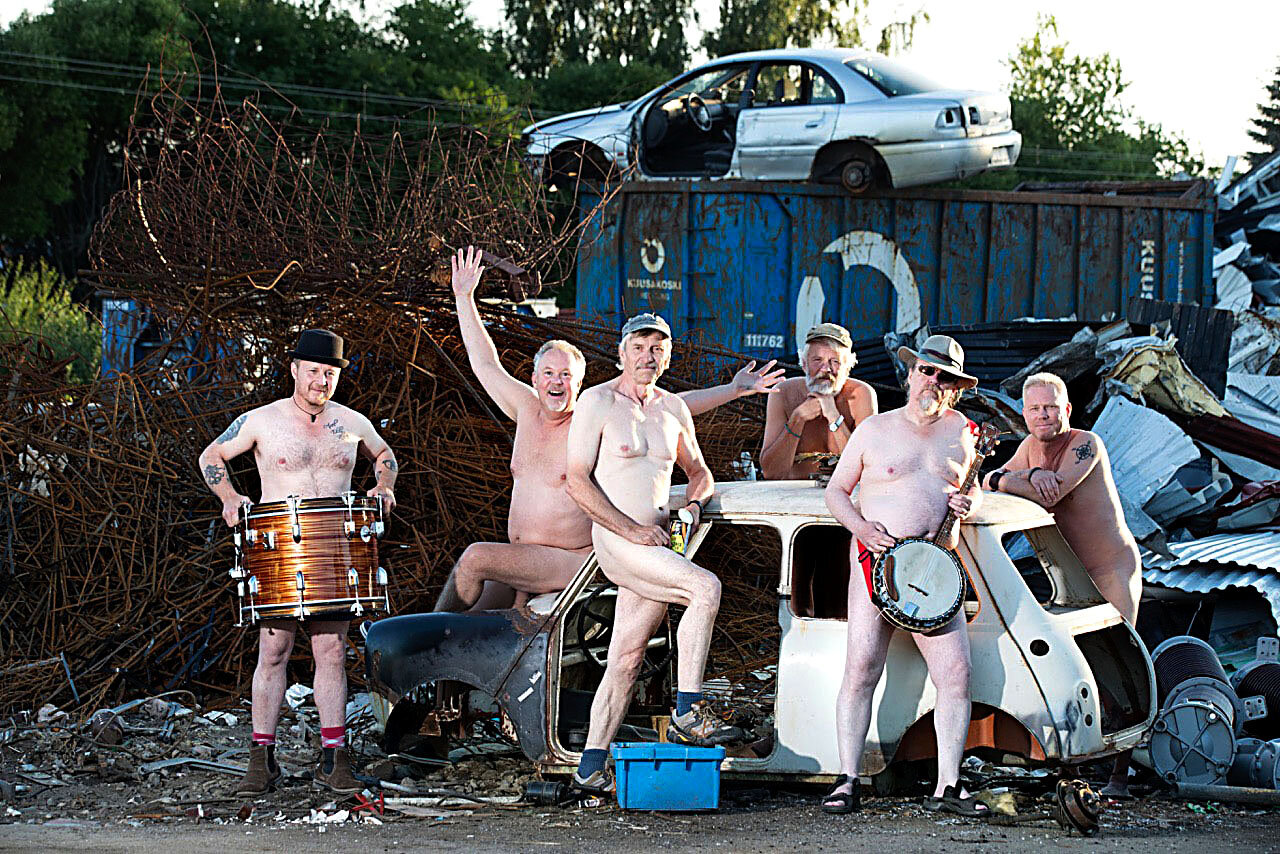 Den nakna sanningen om gruppen Euskefeurat!  När Jutiskalendern, som ges ut av Jutis byaförening till förmån i kampen mot cancer, ville ha en bild på Piteågruppen Euskefeurat som omslagsbild blev jag ombedd att fotografera en nakenbild på den populära gruppen. I samråd med min gamla fotokollega och musikerkompis Robert Lundberg som ingår i gruppen hittade vi en perfekt miljö. På skrotgården runt en gammal kaross från en “hundkoja” i kvällens motljus. Motljuset lättades upp av ateljéblixtar och lyste upp deras bländande vita kroppar, som tydligen trivs bättre i scenljus än i solljus.  En av mina roligaste gruppbilder i karriären!