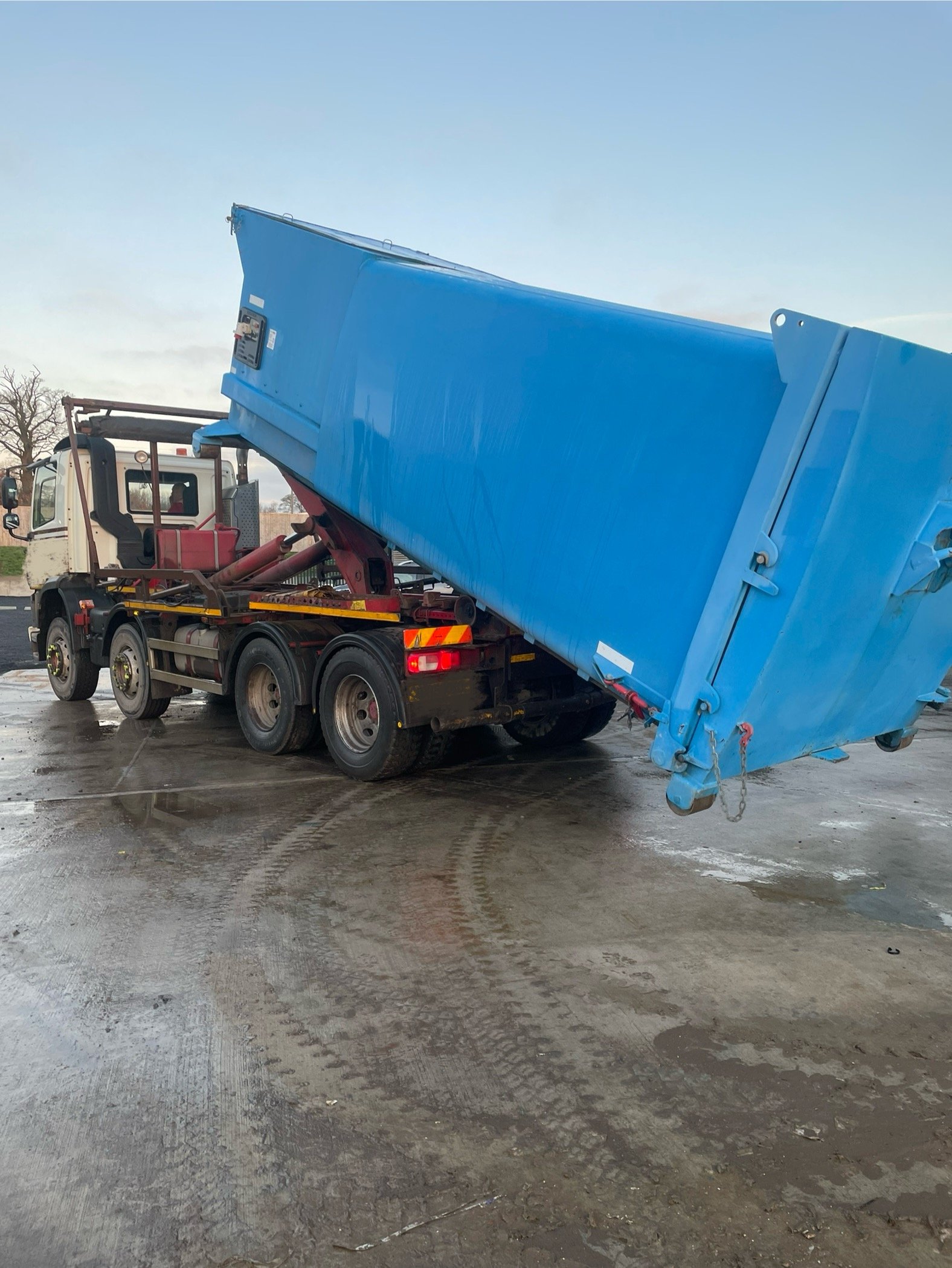 a portable compactor being loaded onto a lorry