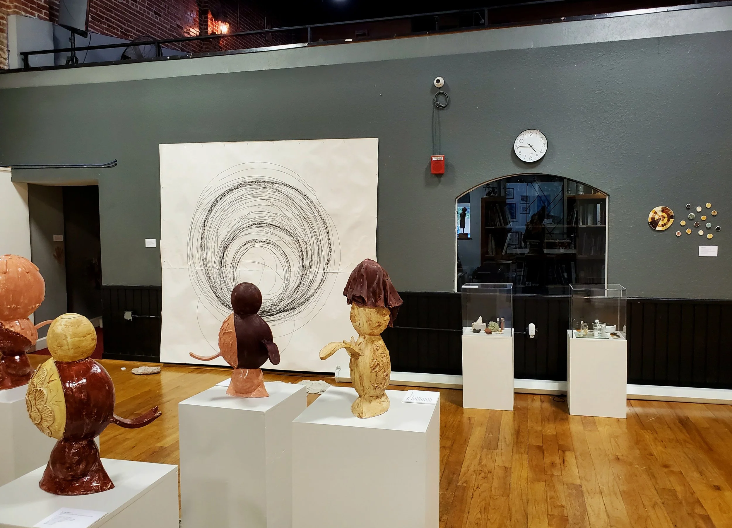 interior view of LAC gallery facing south wall showing 4 ceramic sculptures in the center and a large circle collaboration artwork on the wall
