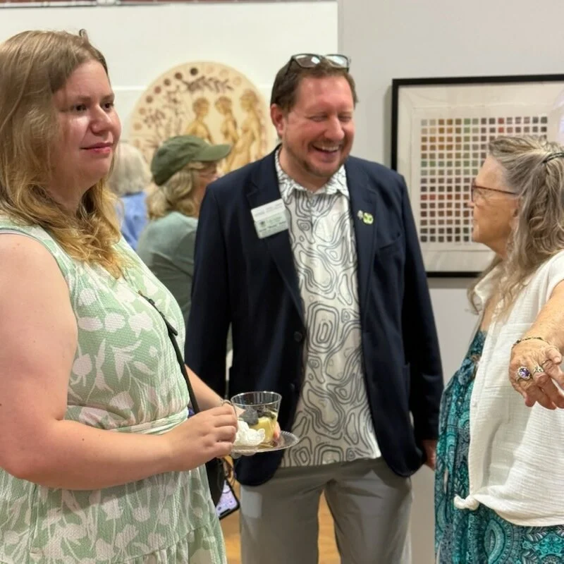 interior view of the gallery during the opening reception showing many visitors interacting with each other and viewing the artwork
