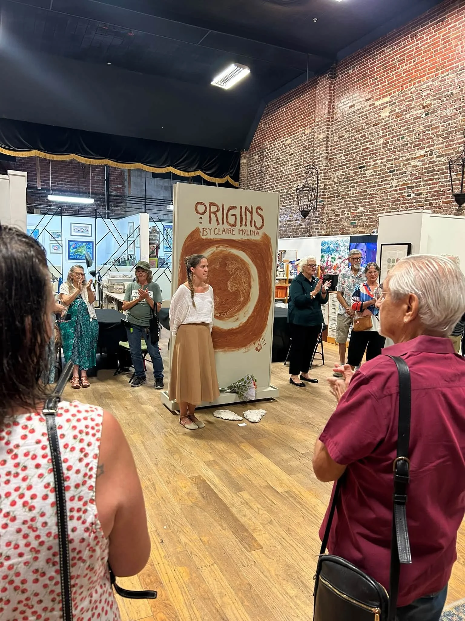 interior view of the gallery during the opening reception showing many visitors interacting with the artist and viewing the artwork