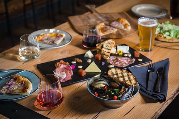 plated appetizers, charcuterie, beer and wine on a table in the lounge.