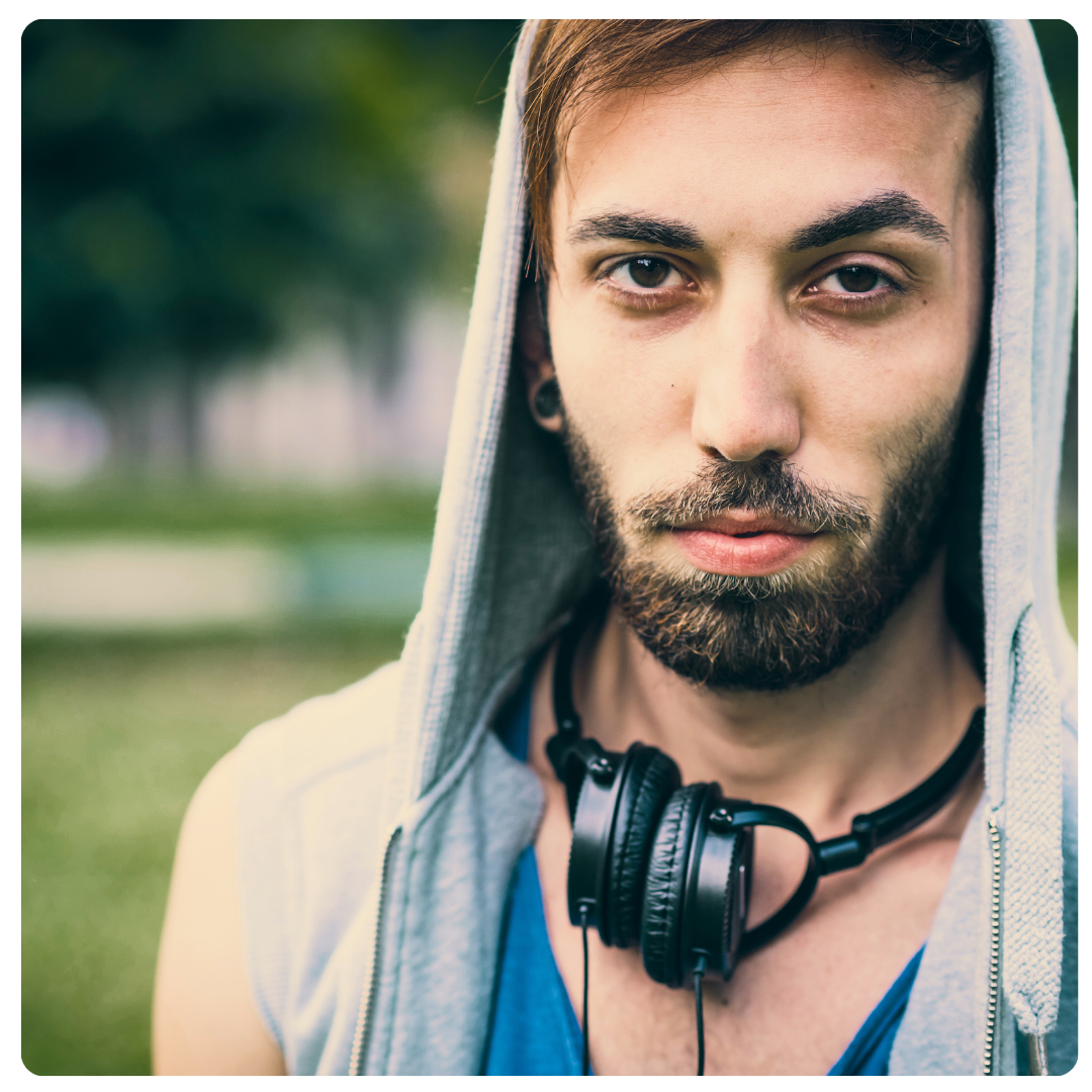 Man in hoodie looks at camera, no expression.