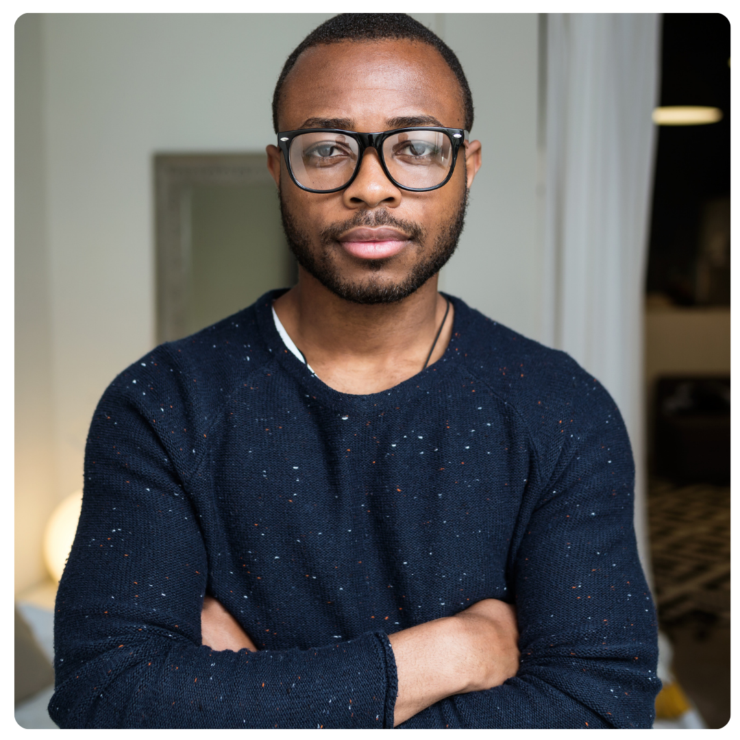 Man without expression, arms crossed in front, looking directly at camera.