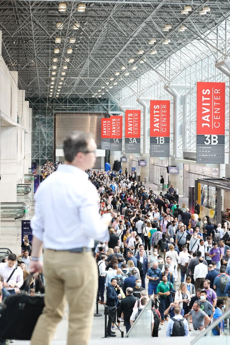 Busy corporate exhibitors showcasing technology solutions at the Amazon Web Services Summit at the Javits Center in New York City