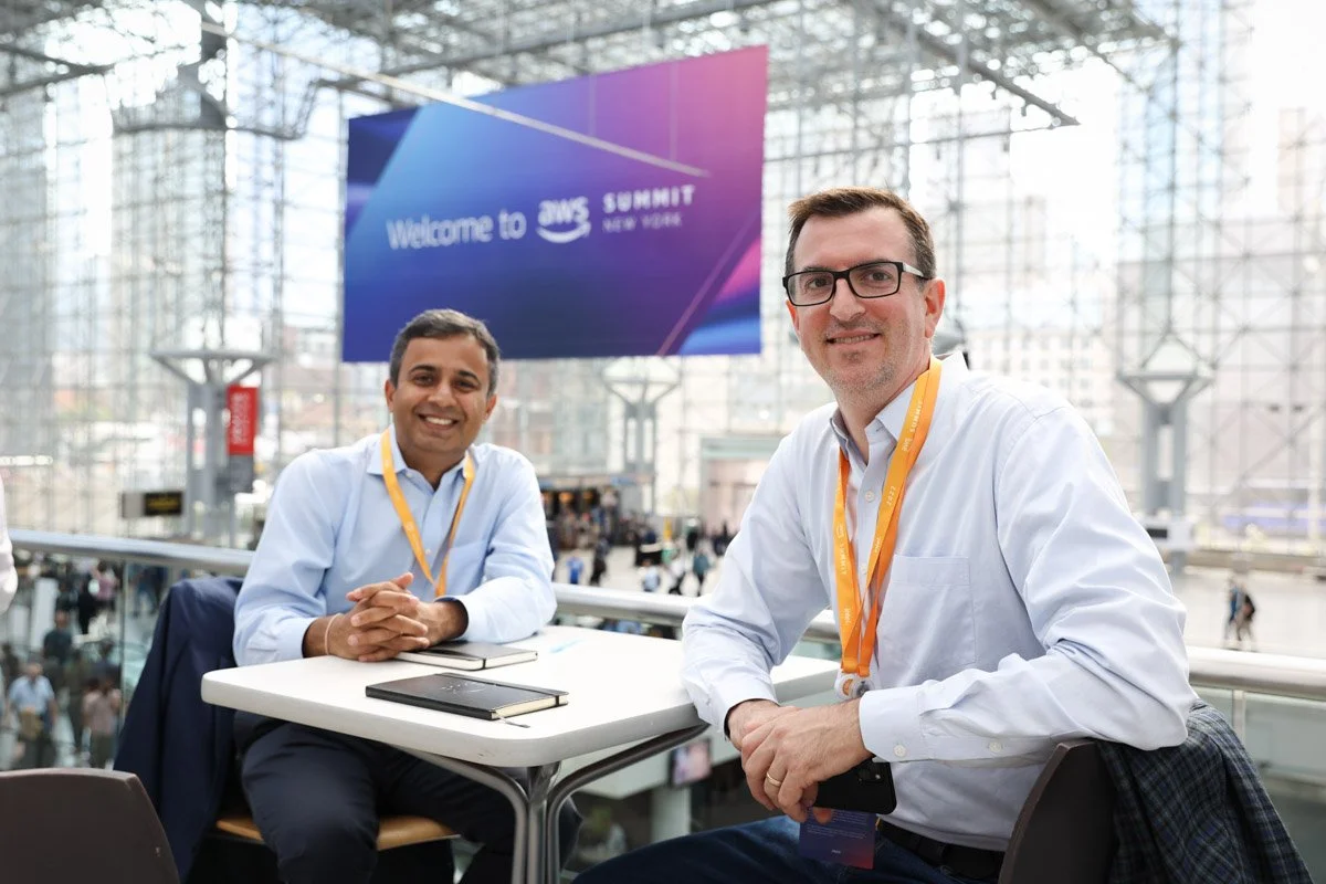 Busy corporate exhibitors showcasing technology solutions at the Amazon Web Services Summit at the Javits Center in New York City