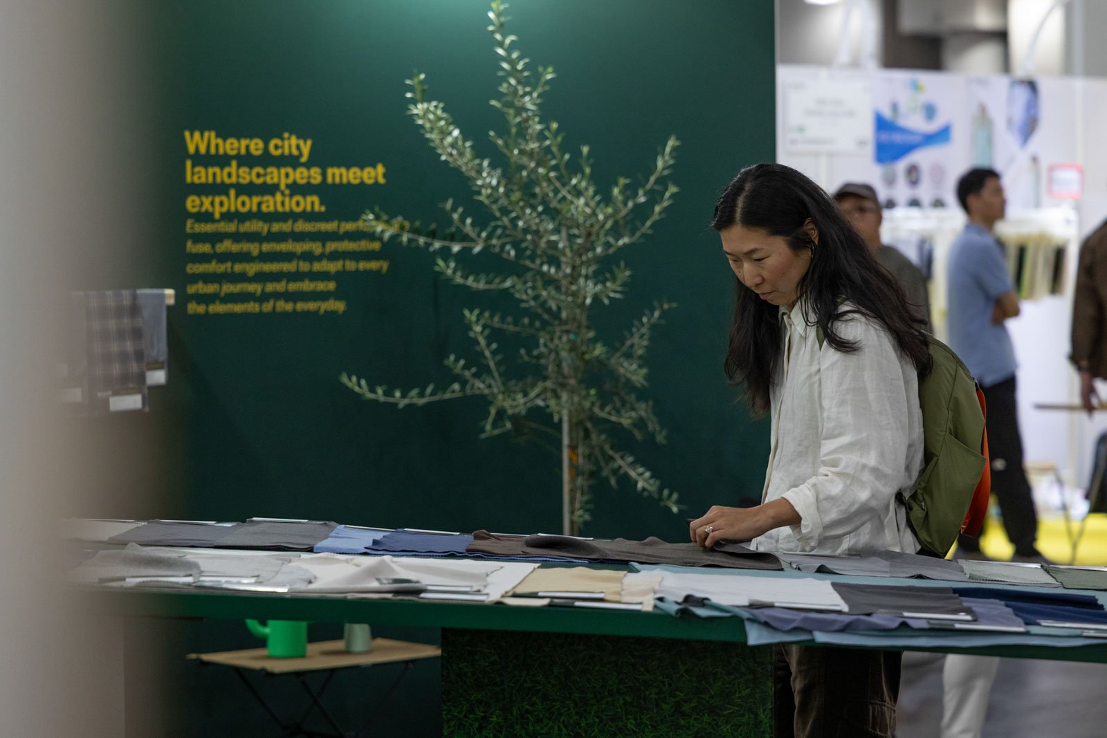 Texworld NYC attendee examining textile fabrics at an exhibitor booth at Javits Center
