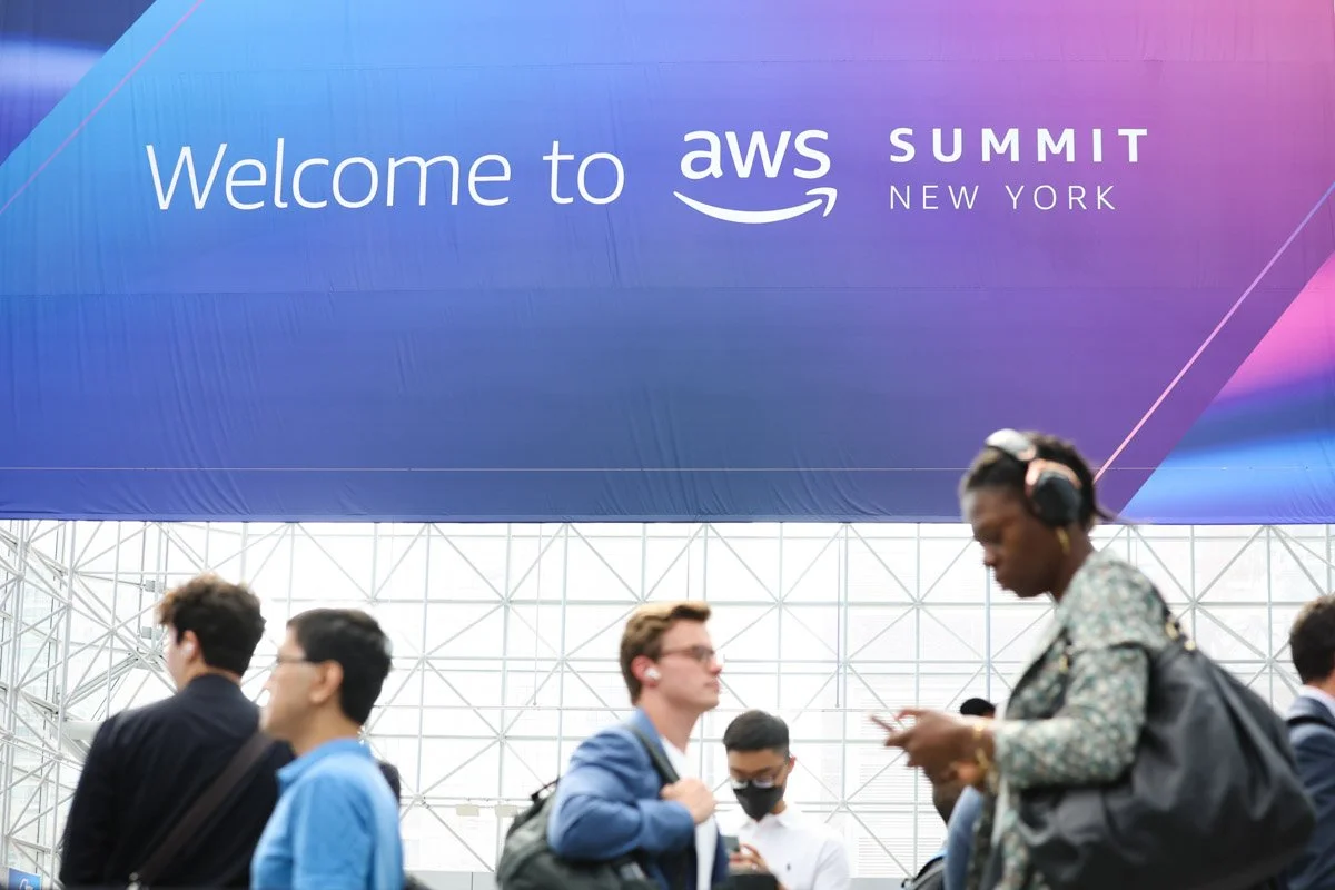 Busy corporate exhibitors showcasing technology solutions at the Amazon Web Services Summit at the Javits Center in New York City