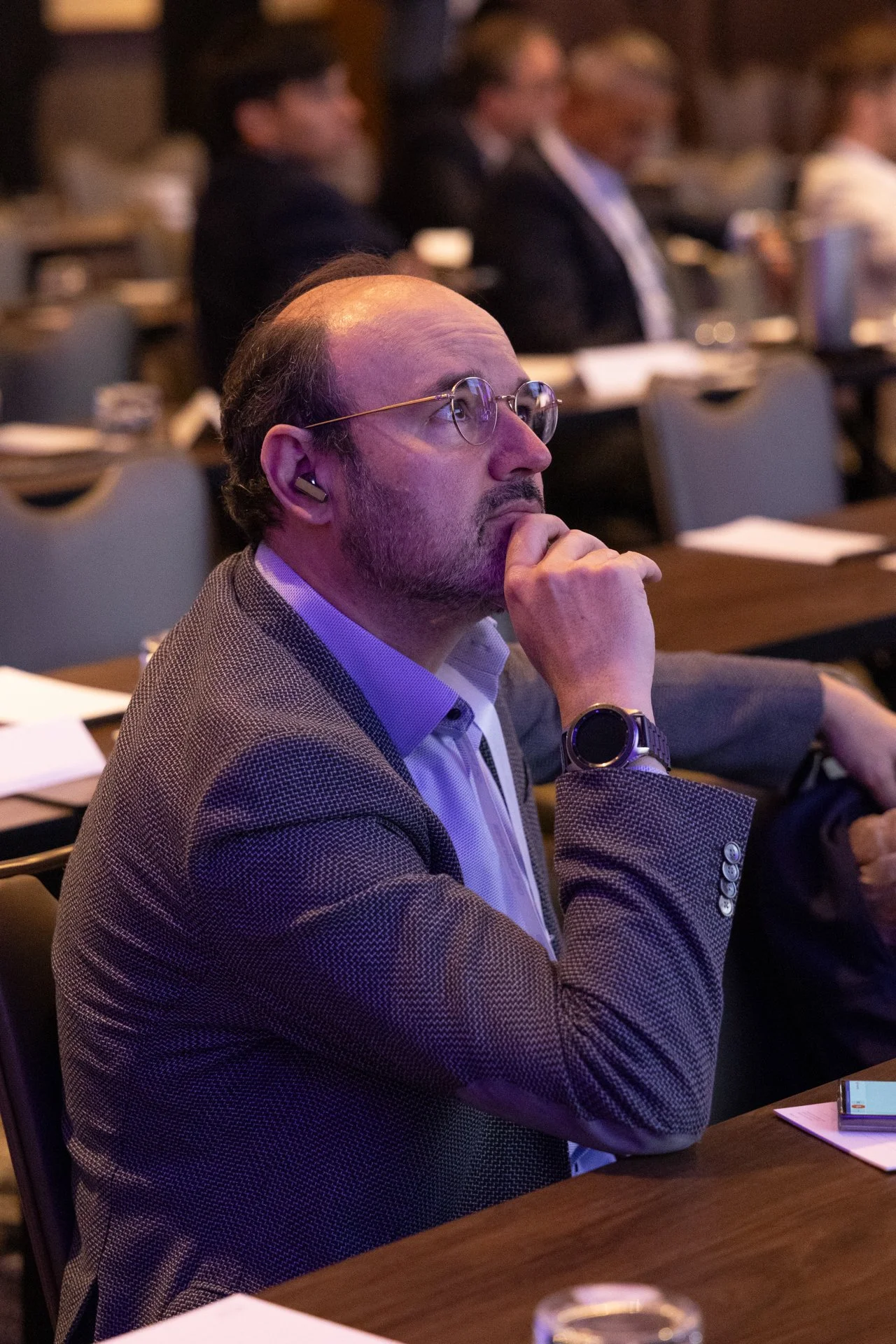 man paying attention to speaker on stage