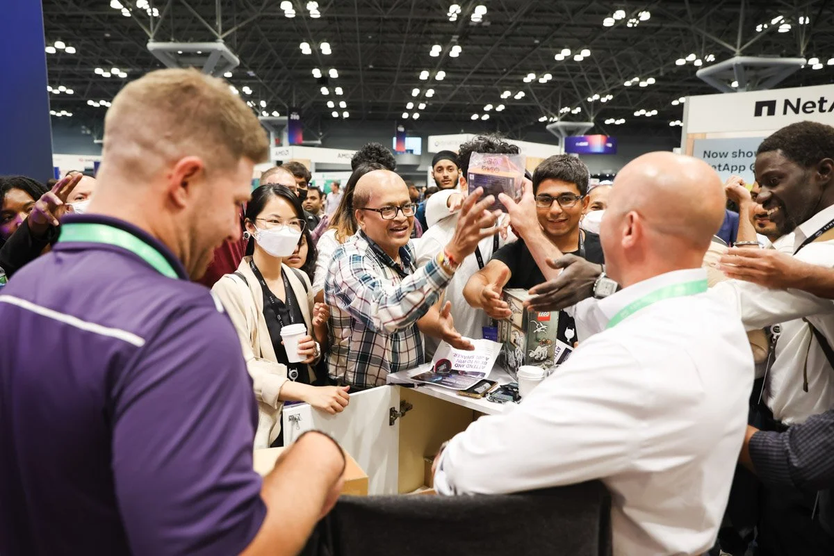 Busy corporate exhibitors showcasing technology solutions at the Amazon Web Services Summit at the Javits Center in New York City