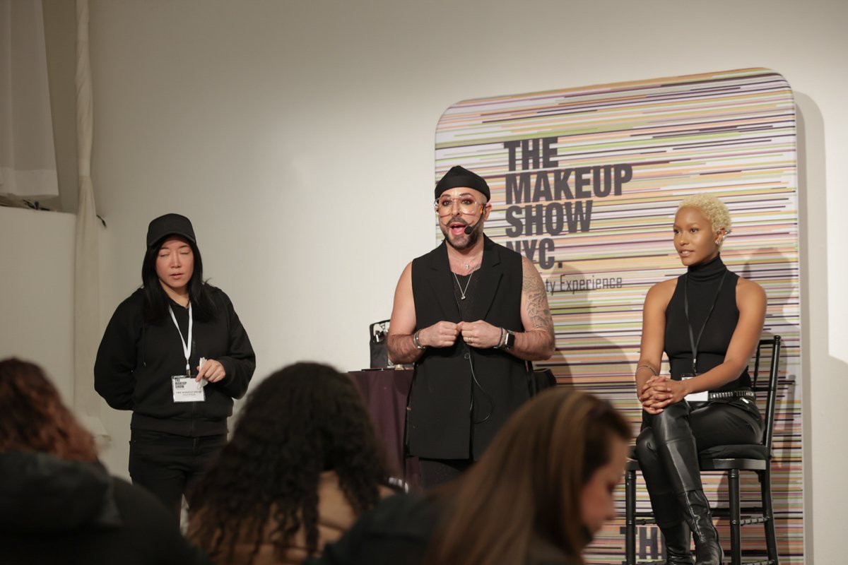 Beauty professionals present to attendees during a live demonstration at The Makeup Show NYC.