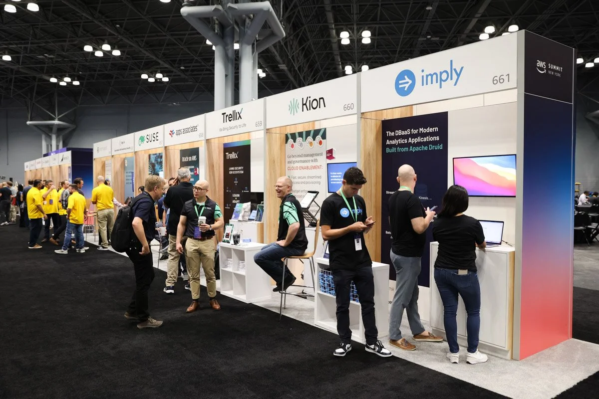 Busy corporate exhibitors showcasing technology solutions at the Amazon Web Services Summit at the Javits Center in New York City.