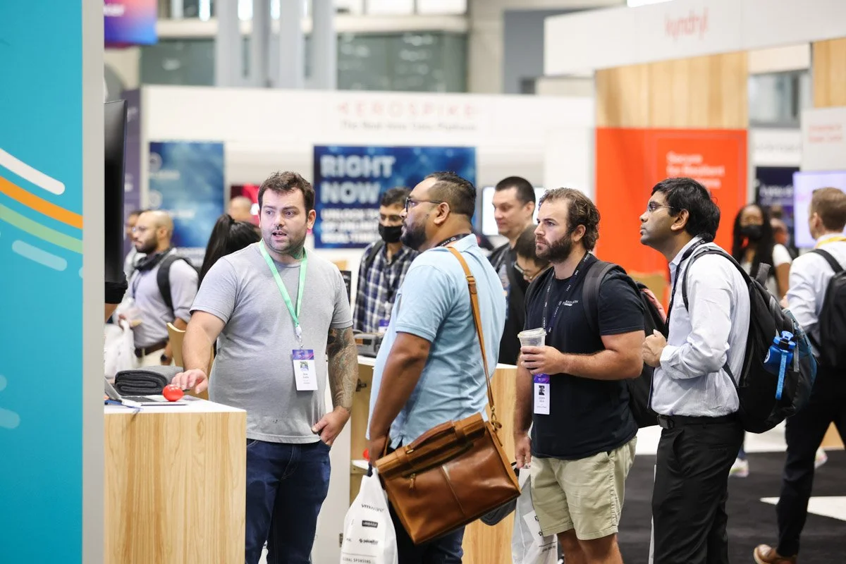 Busy corporate exhibitors showcasing technology solutions at the Amazon Web Services Summit at the Javits Center in New York City