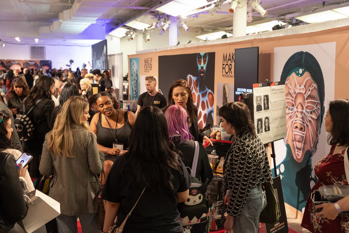 Beauty professionals explore exhibitor booths and product displays on the busy floor at The Makeup Show NYC.