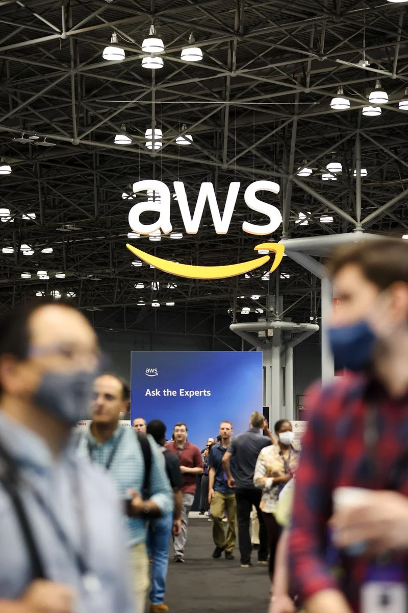 Busy corporate exhibitors showcasing technology solutions at the Amazon Web Services Summit at the Javits Center in New York City