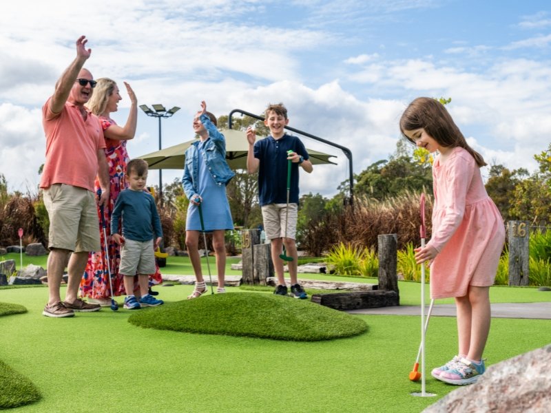family playing putt putt at noosa mini golf
