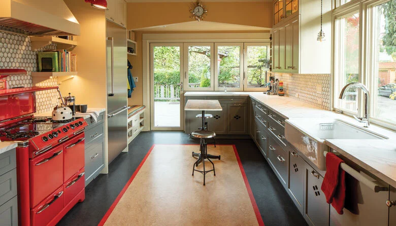 Image Credit: Alex CrookColor Play | Design and color consultant Emily Lauderback coordinated the palette in the kitchen around the red stove, updating the room while maintaining its charming vintage vibe.