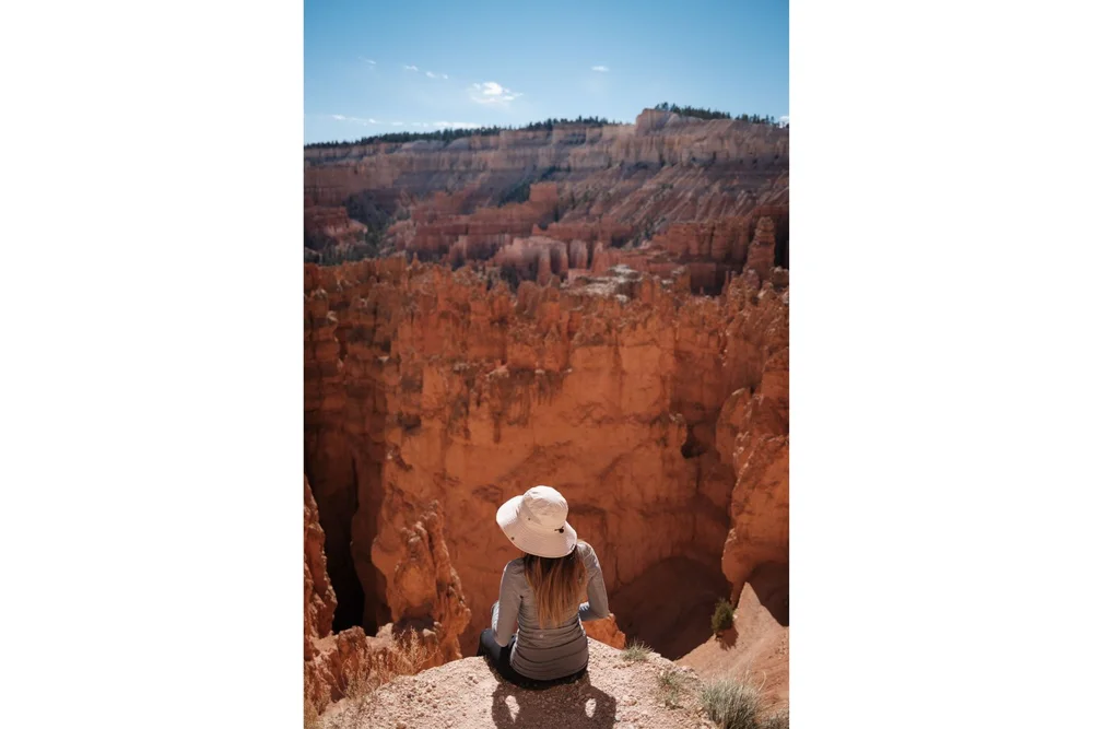 Sitting on a cliff with red hoodoos Navaho Loop Trail in Bryce Canyon