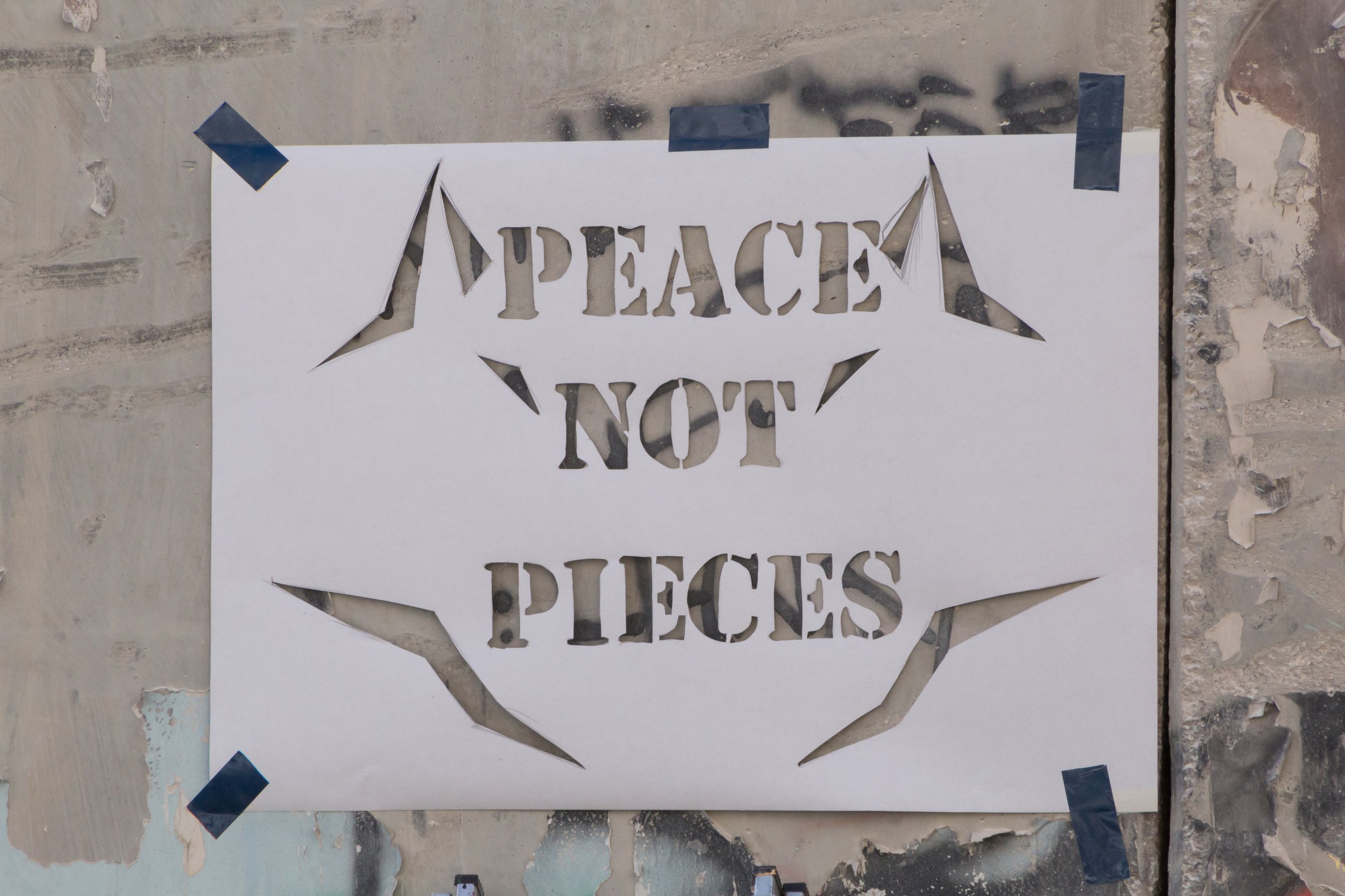 Image of a sign reading 'peace not pieces'