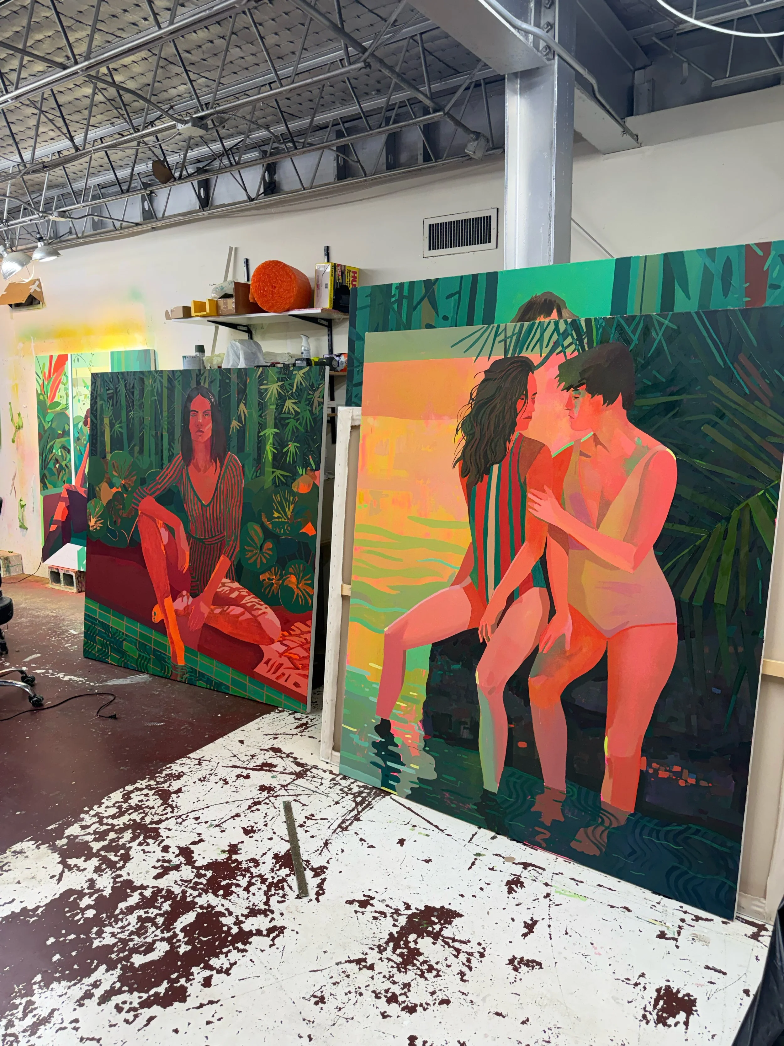 Colorful figurative paintings by Patrick Puckett arranged in the studio.