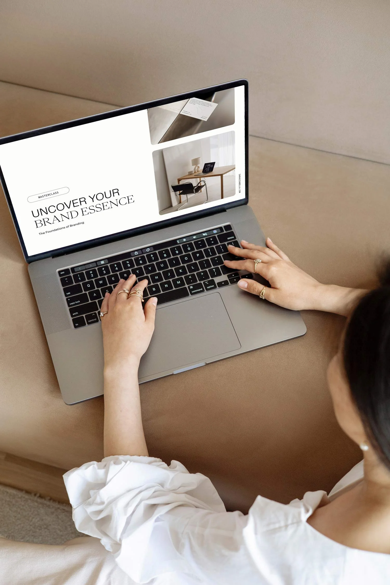 Woman looks at a laptop with the "Uncover Your Brand Essence" Masterclass open.