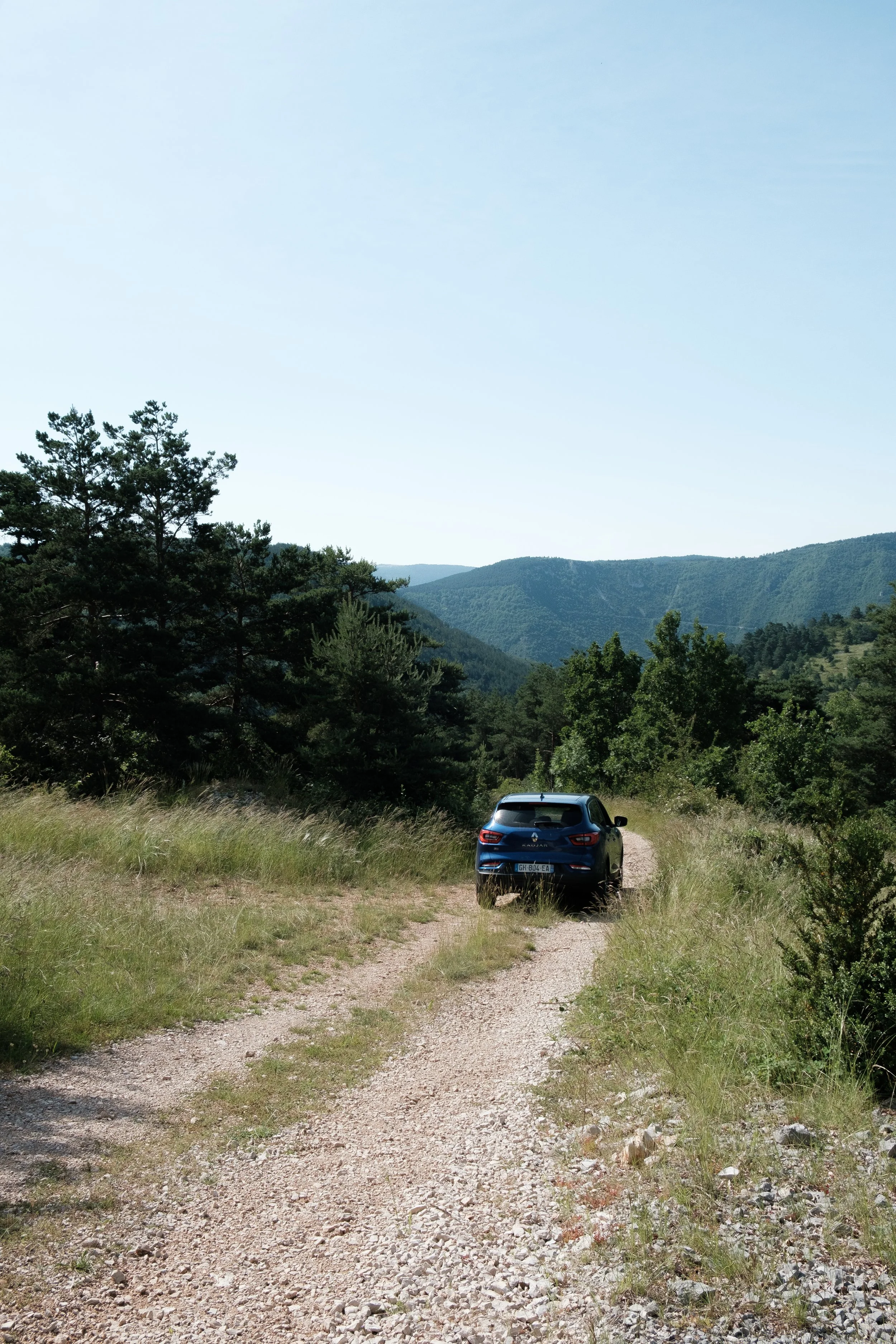 Car driving on gravel road in Lozère South France 