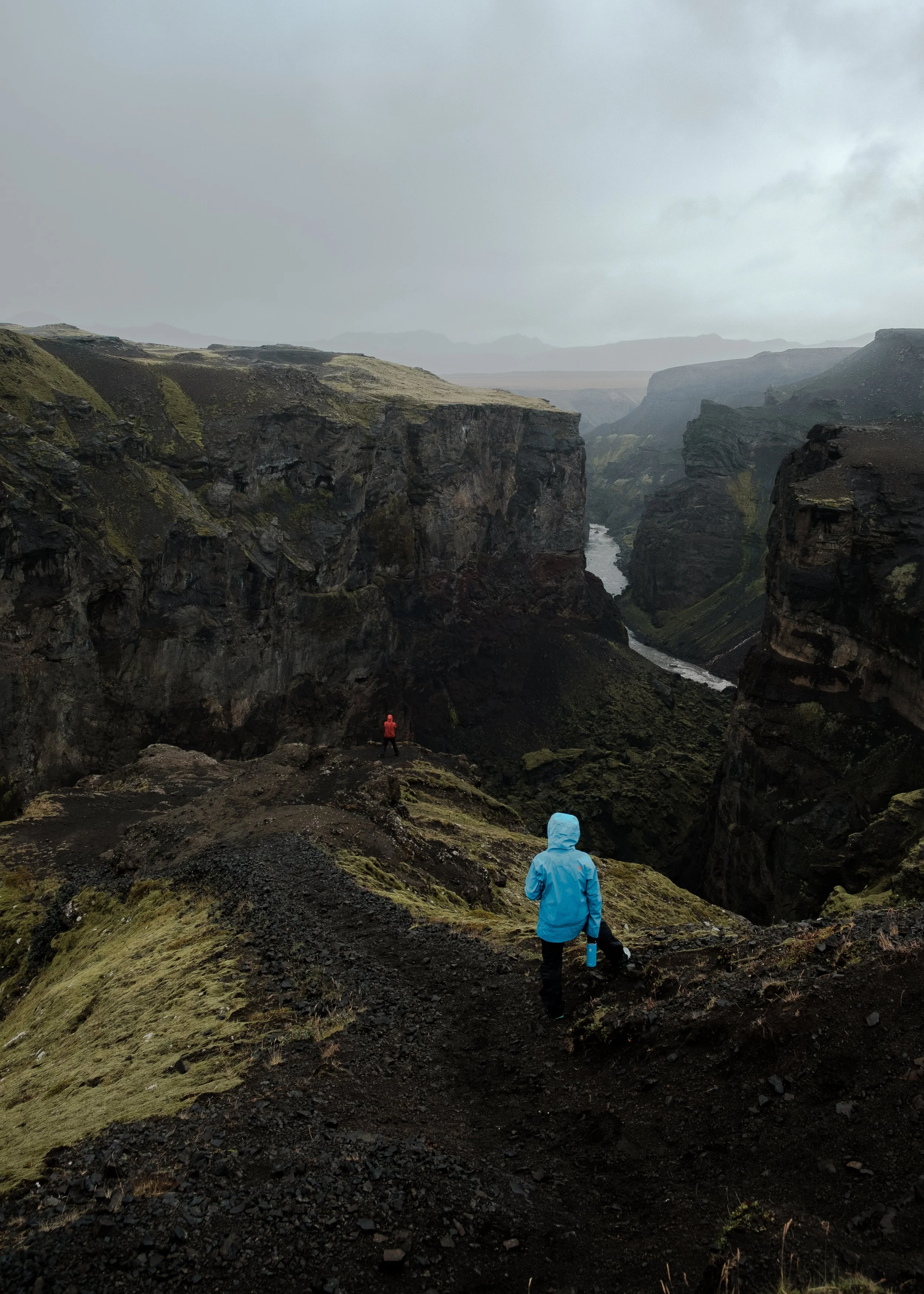 Couple standing near the edge of a cliff in Iceland