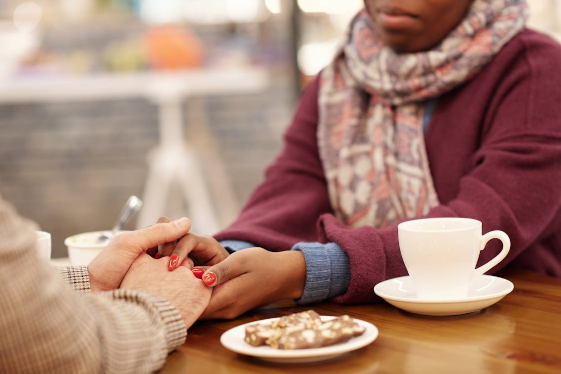 People holding hands over a table