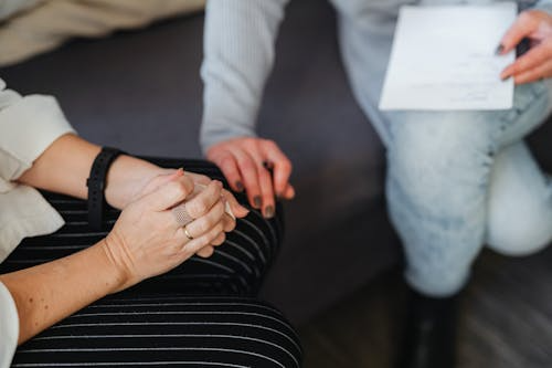 A therapist placing her hand on knee of a client trying to console them
