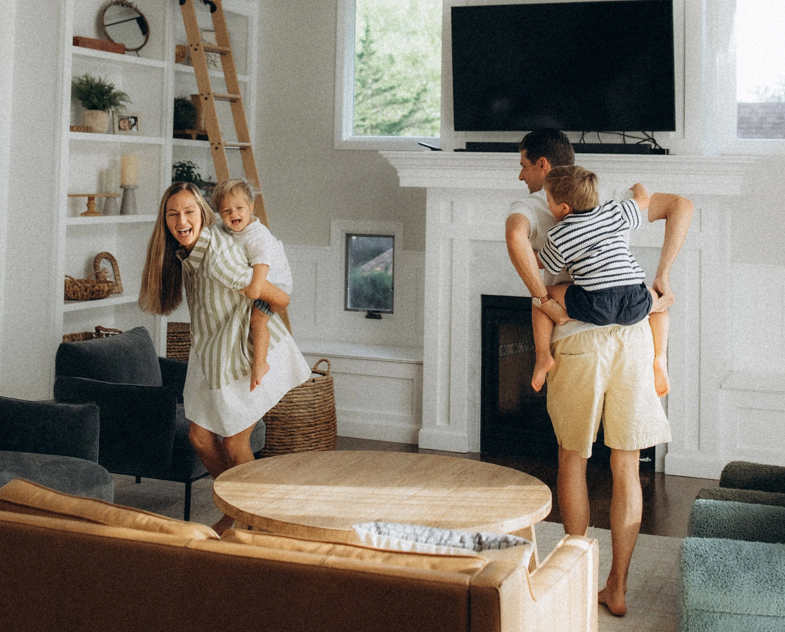 Parents playing with children inside giving piggy back rides
