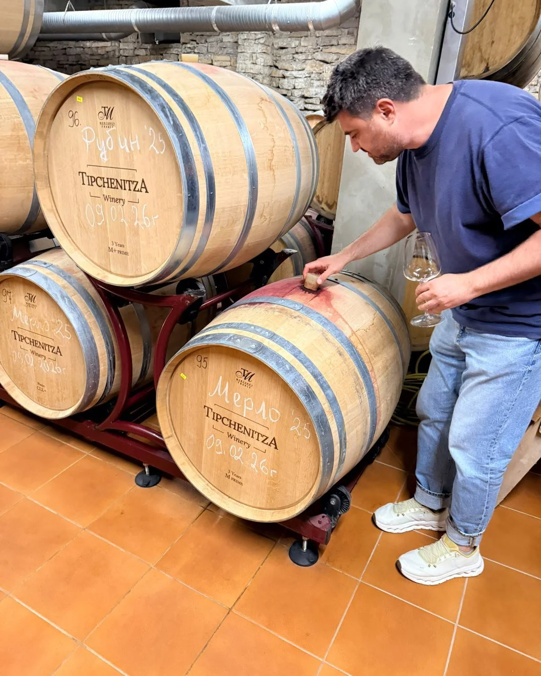Svetoslav Stoyanov tasting wine from the barrel in a winery cellar