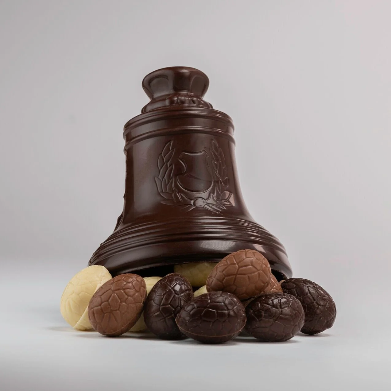 Cloche de Pâques en chocolat noir garnie de petits œufs en chocolat Maison Nihoul.