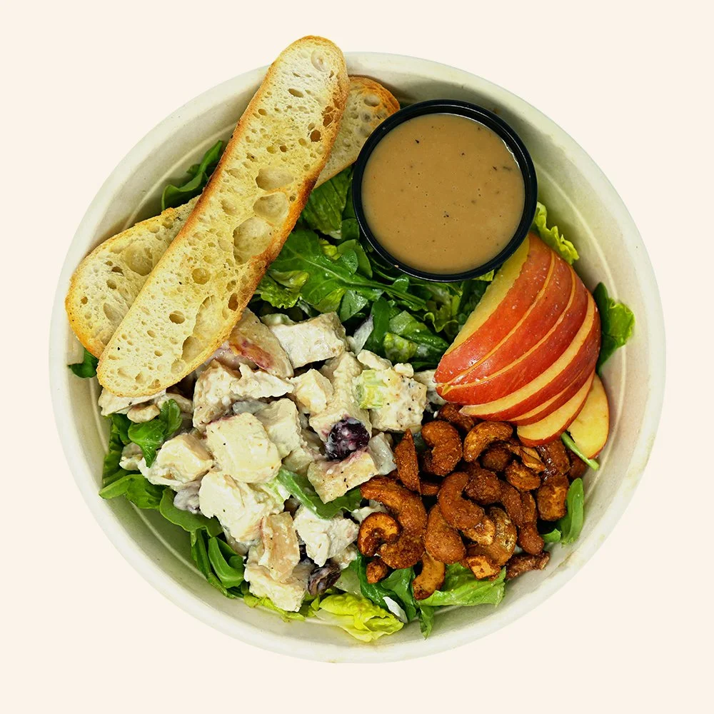 CHICKEN WALDORF - Romaine, arugula, Honeycrisp apple, candied cashews, topped with housemade chicken salad with a balsamic vinaigrette. Served with toasted ciabatta.