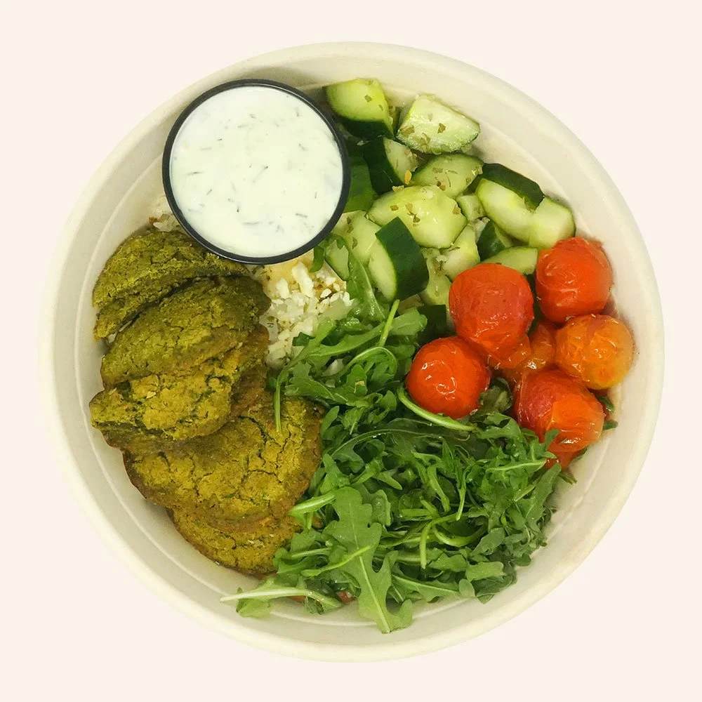 MEDITERRANEAN FALAFEL - Baked falafel, cucumber, arugula, pickled onion, blistered tomato, feta melted over jasmine rice, with a garlic aioli drizzle, oregano and tzatziki.