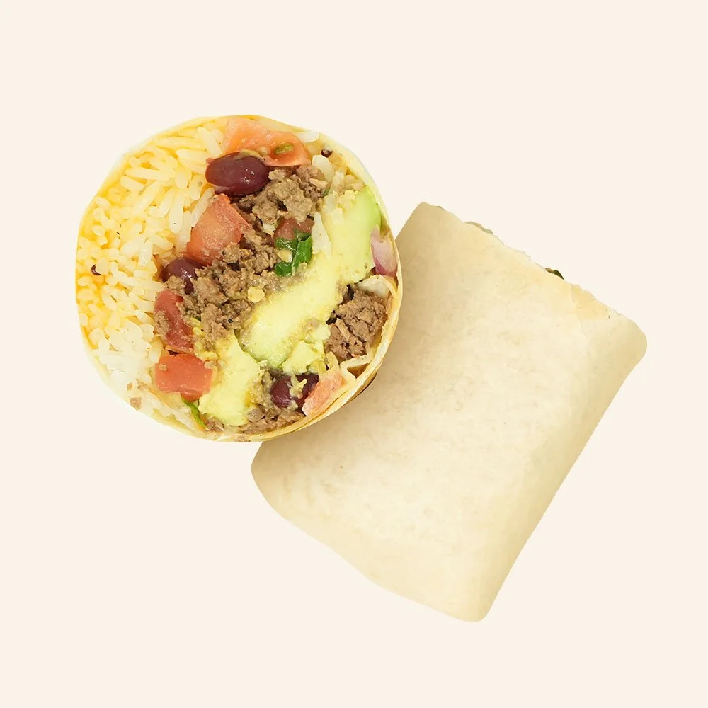 RANCHERO BURRITO - Seasoned grass-fed ground beef, pico de gallo, rice, kidney beans, cheese blend, avocado, Baja ranch drizzle in a tortilla.