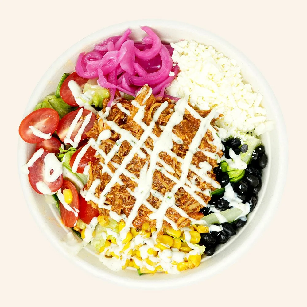 BBQ CHICKEN - Romaine lettuce, black beans, roasted corn, tomato, pickled onion, cotija cheese, shredded bbq chicken, served with ranch dressing.