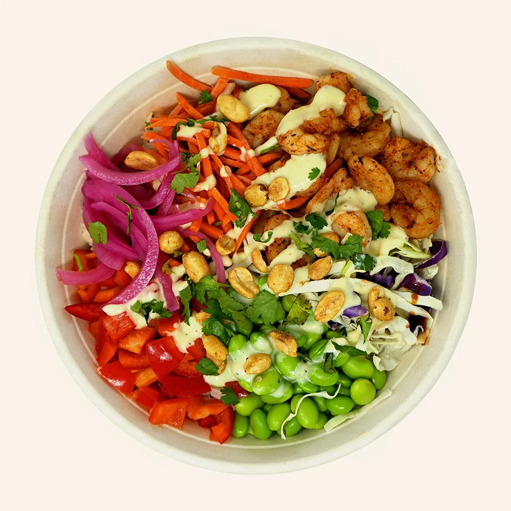 SHRIMP STIRFRY - Blackened shrimp, jasmine rice, cabbage, carrot, edamame, red bell pepper, pickled onion, stir fry sauce, topped with peanuts and cilantro with a garlic aioli drizzle.