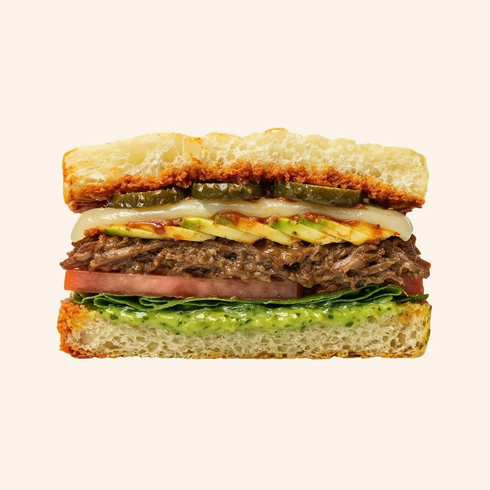 BEEF BARBACOA - Housemade organic focaccia, slow cooked grass fed beef, romaine, tomato, cheese blend, candied jalapeno, adobo sauce, and avocado salsa.