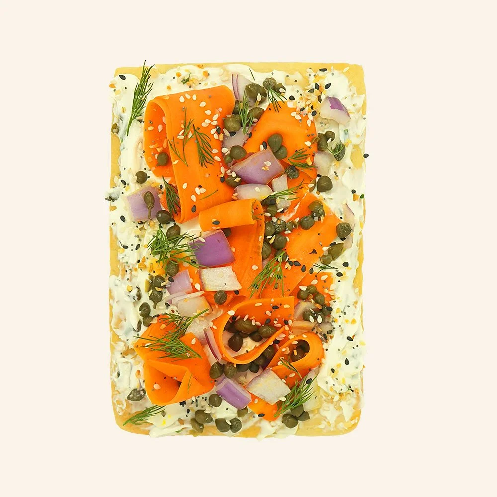 SMOAKED "LOX" TOAST - Cream cheese infused with scallions on house made organic focaccia bread, smoked carrots, red onion, capers, dill and everything bagel seasoning.