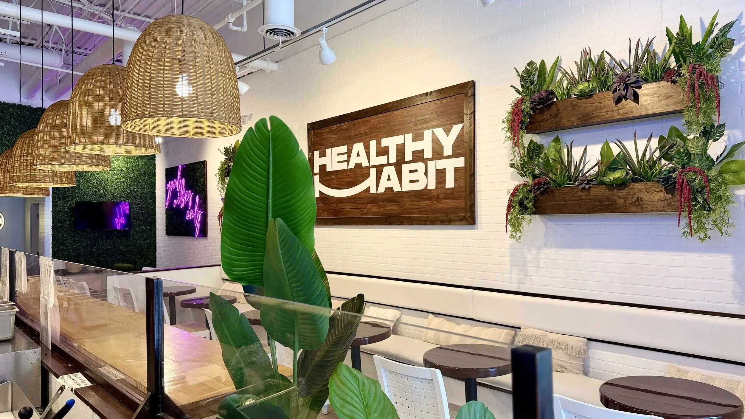 Interior of a health-focused restaurant with a large wooden sign that says 