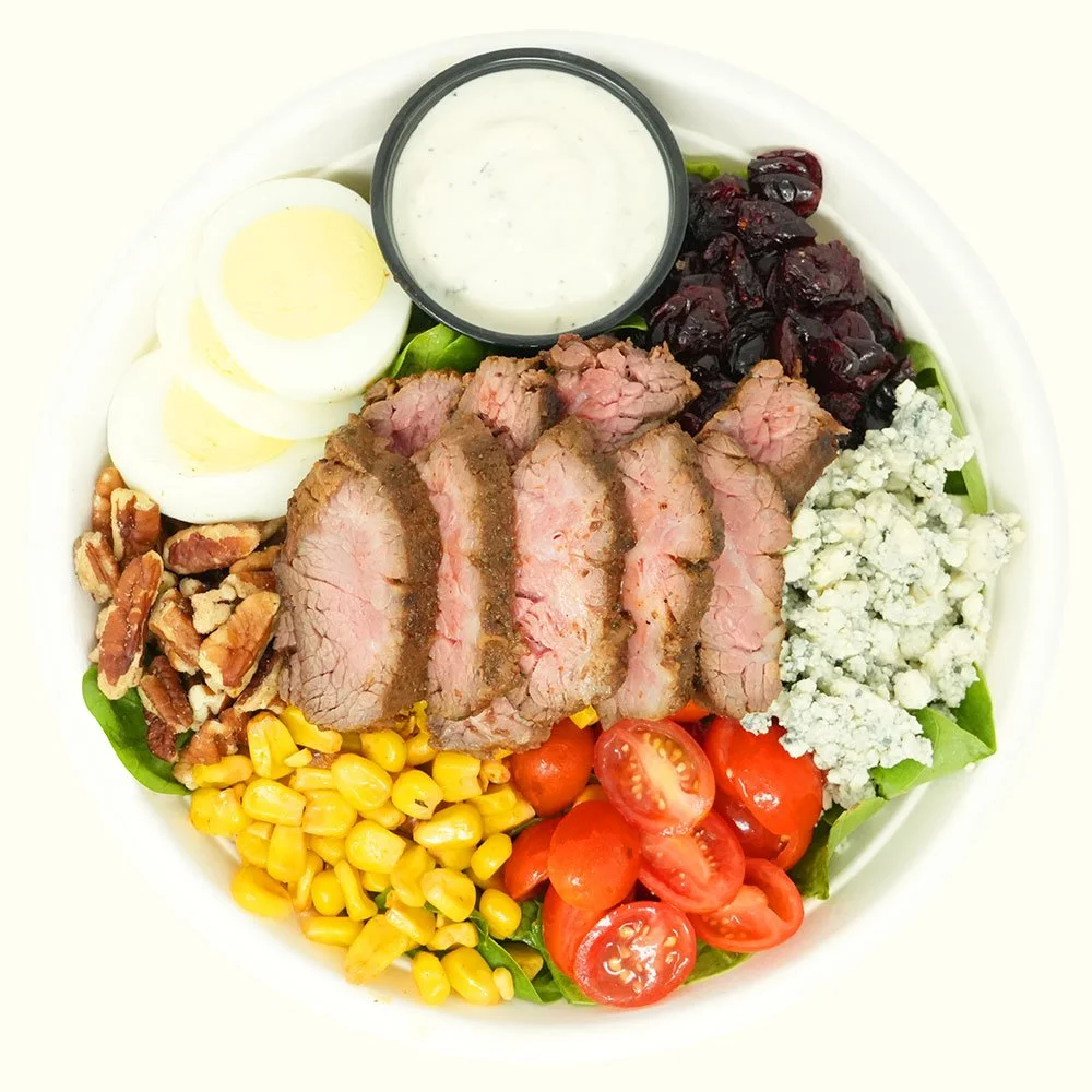 Americana Steak - Grass-fed steak, romaine lettuce, spinach, tomato, roasted corn, hard
boiled egg, bleu cheese, cranberries, pecans served with ranch.