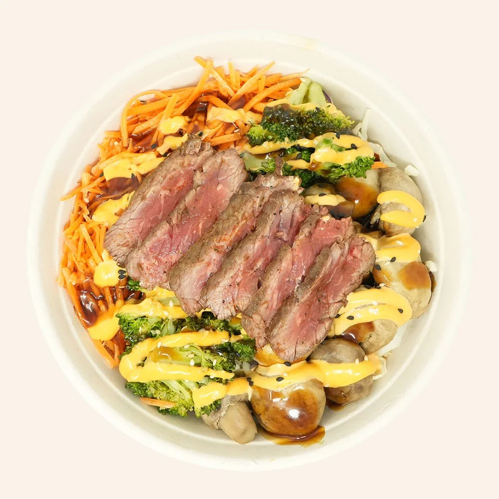 STEAK KOREAN - Grass-fed steak, rice quinoa blend, roasted mushroom, broccoli, shaved carrot and cabbage, sesame seeds, with teriyaki and Korean chili aioli.