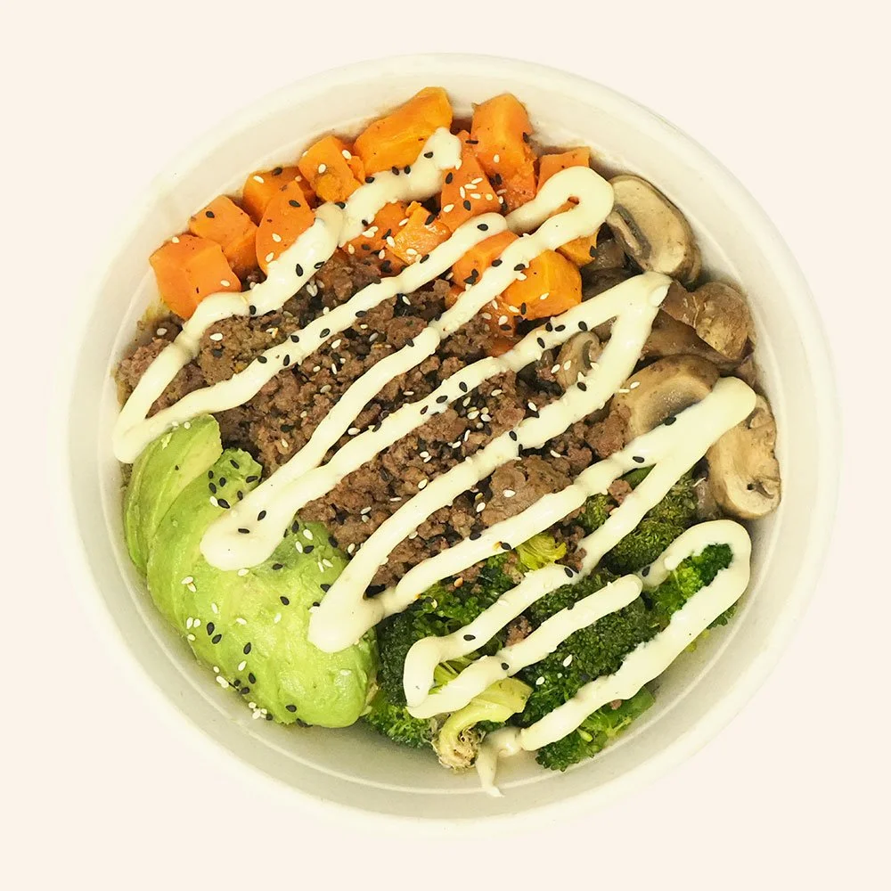 BEEF BUDDHA - Grass fed ground beef, sweet potato, roasted mushroom, roasted broccoli, avocado, quinoa, with a garlic aioli drizzle and topped with sesame seeds.