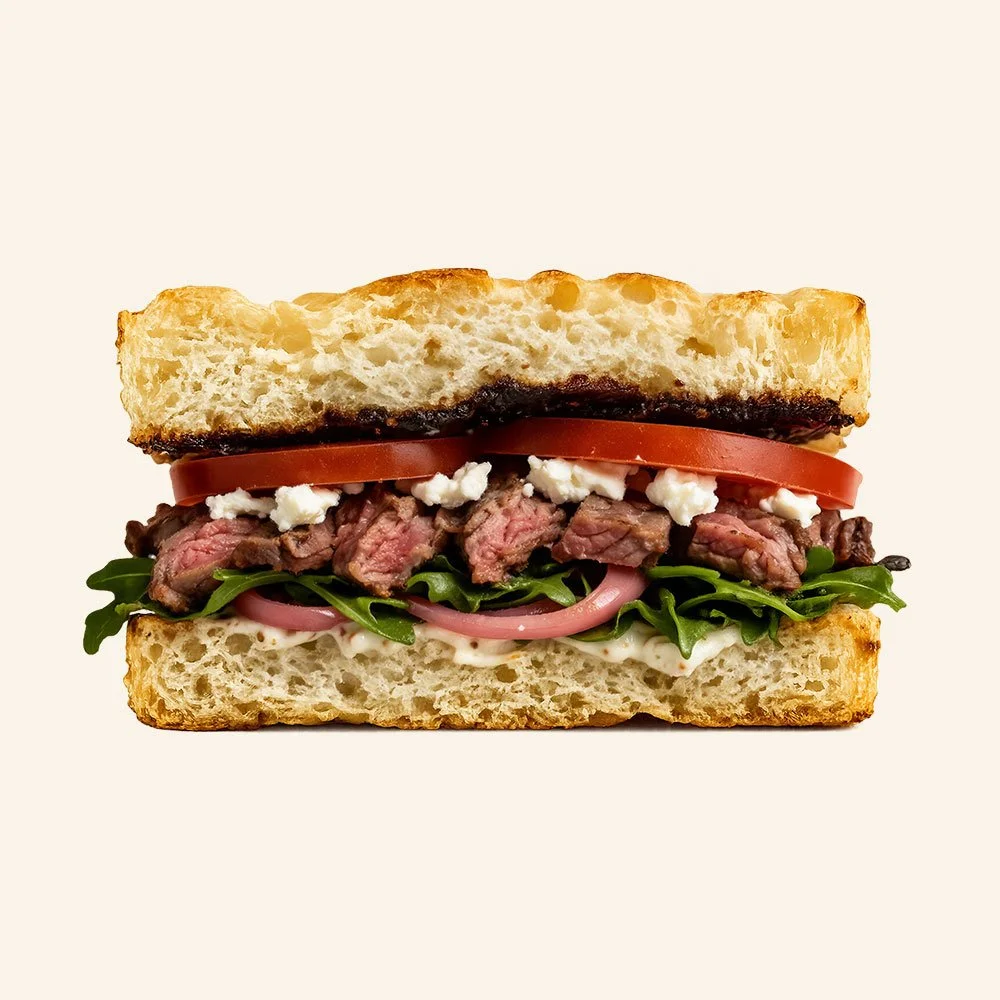 STEAK & FIG - Housemade organic focaccia, grass fed steak, roasted onion, tomato, arugula, garlic aioli, goat cheese, fig jam.