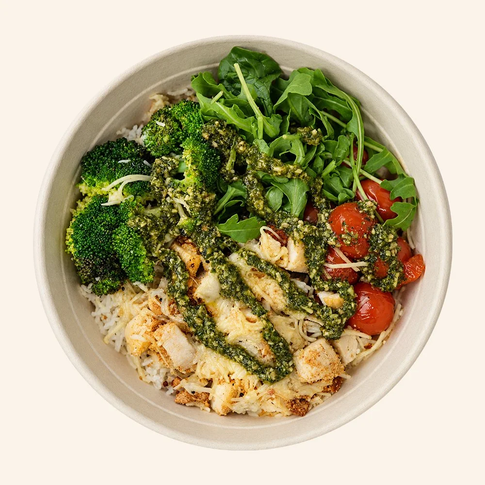 CHICKEN BASIL PESTO - All-natural chicken, garlic aioli, jasmine rice, roasted broccoli, blistered tomato, arugula, parmesan, gluten free bread crumbs with balsamic glaze and a basil pesto drizzle.