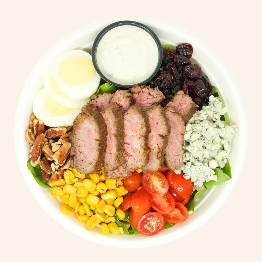 AMERICAN STEAK  - Grass-fed steak, romaine lettuce, spinach, tomato, roasted corn, hard boiled egg, bleu cheese, cranberries, pecans served with ranch.