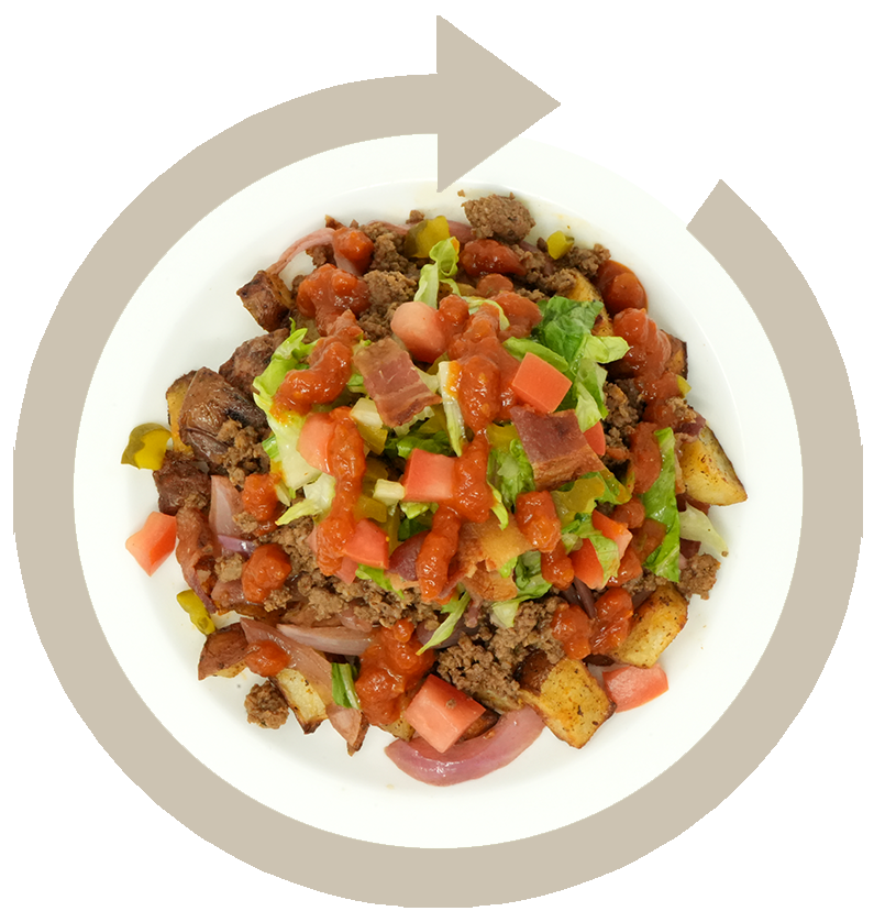 A plate of loaded nachos with ground beef, diced tomatoes, chopped onions, lettuce, and drizzled with salsa.